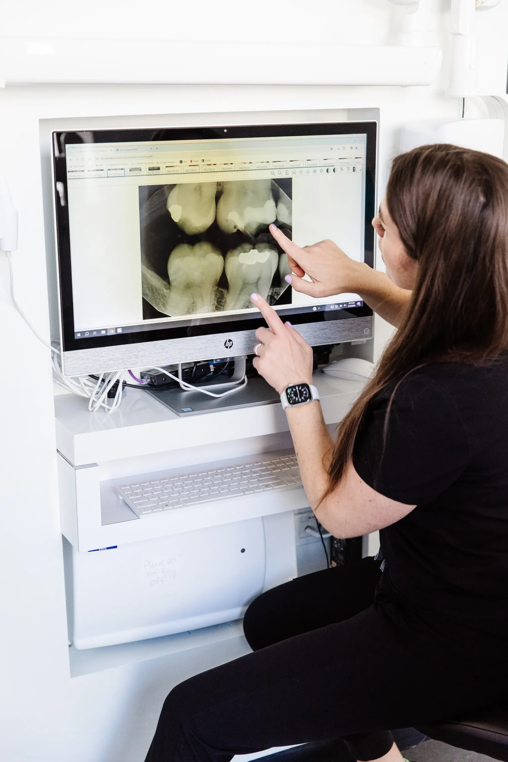 a dental assistant at Dental Studio SF looking at an X-ray 